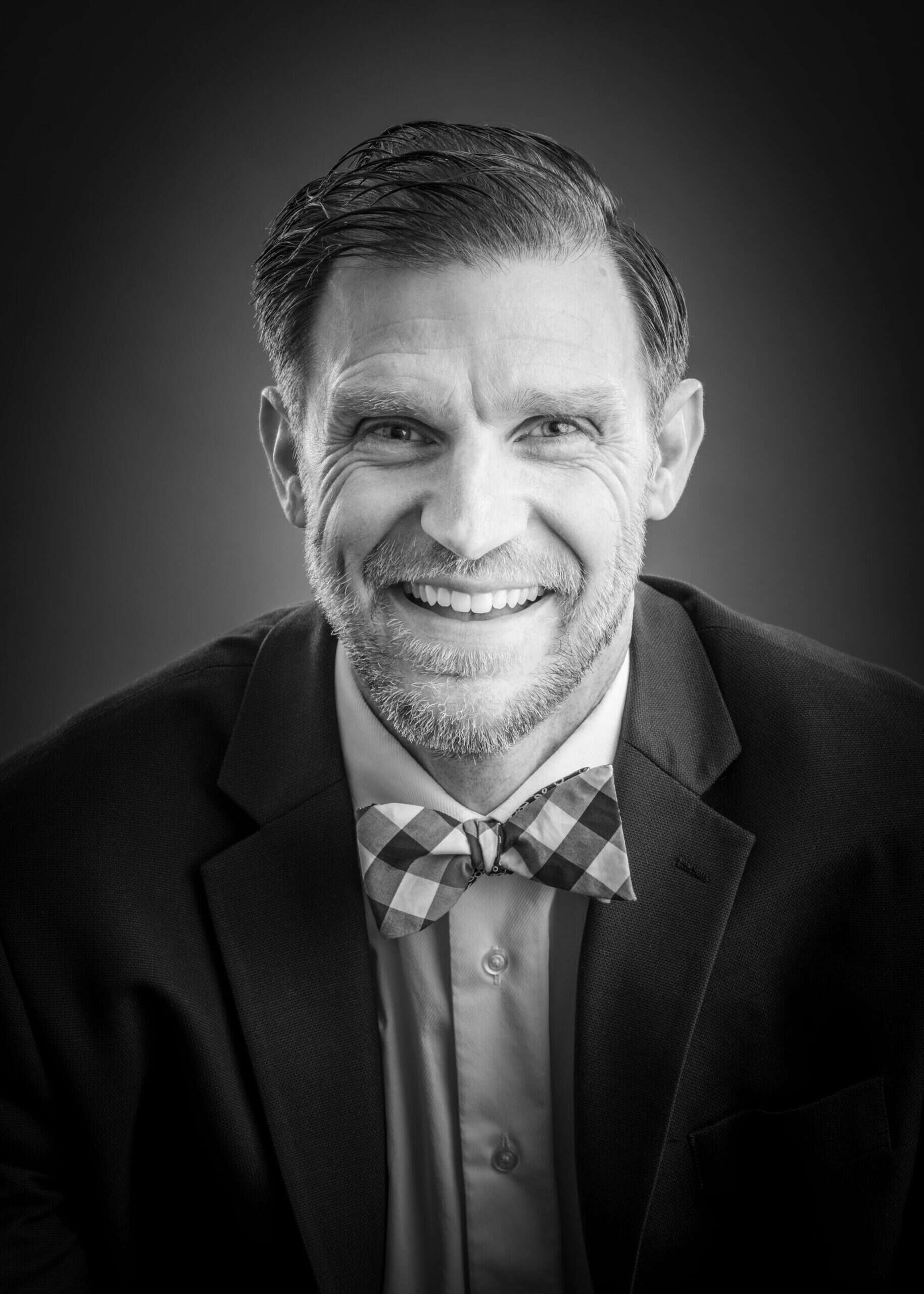 Portrait of a smiling man in a suit and bow tie
