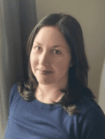 Portrait of a woman with dark hair wearing a blue shirt