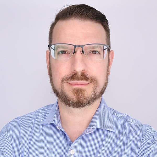 Portrait of a man wearing glasses and a blue checkered shirt
