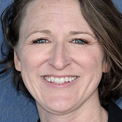 Portrait of a smiling woman with dark hair on a blue background