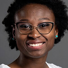 Portrait of a smiling woman wearing glasses and turquoise earrings