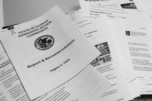 Pile of assorted documents with the top most one displaying the following words: State of Illinois Admissions Review Commission, Report & Recommendations, August 6, 2009.