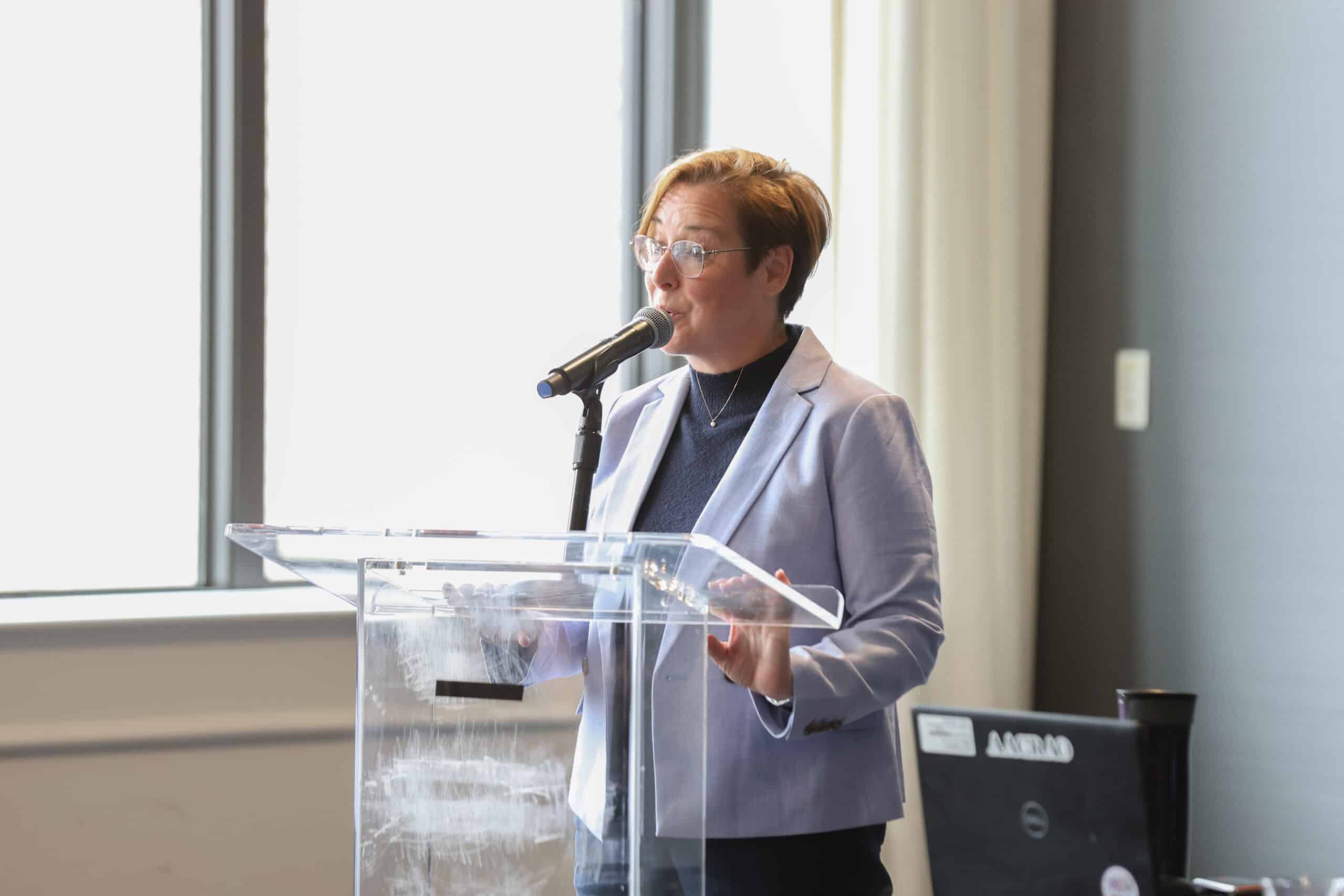 Woman Speaker at a podium speaking at an AACRAO Event