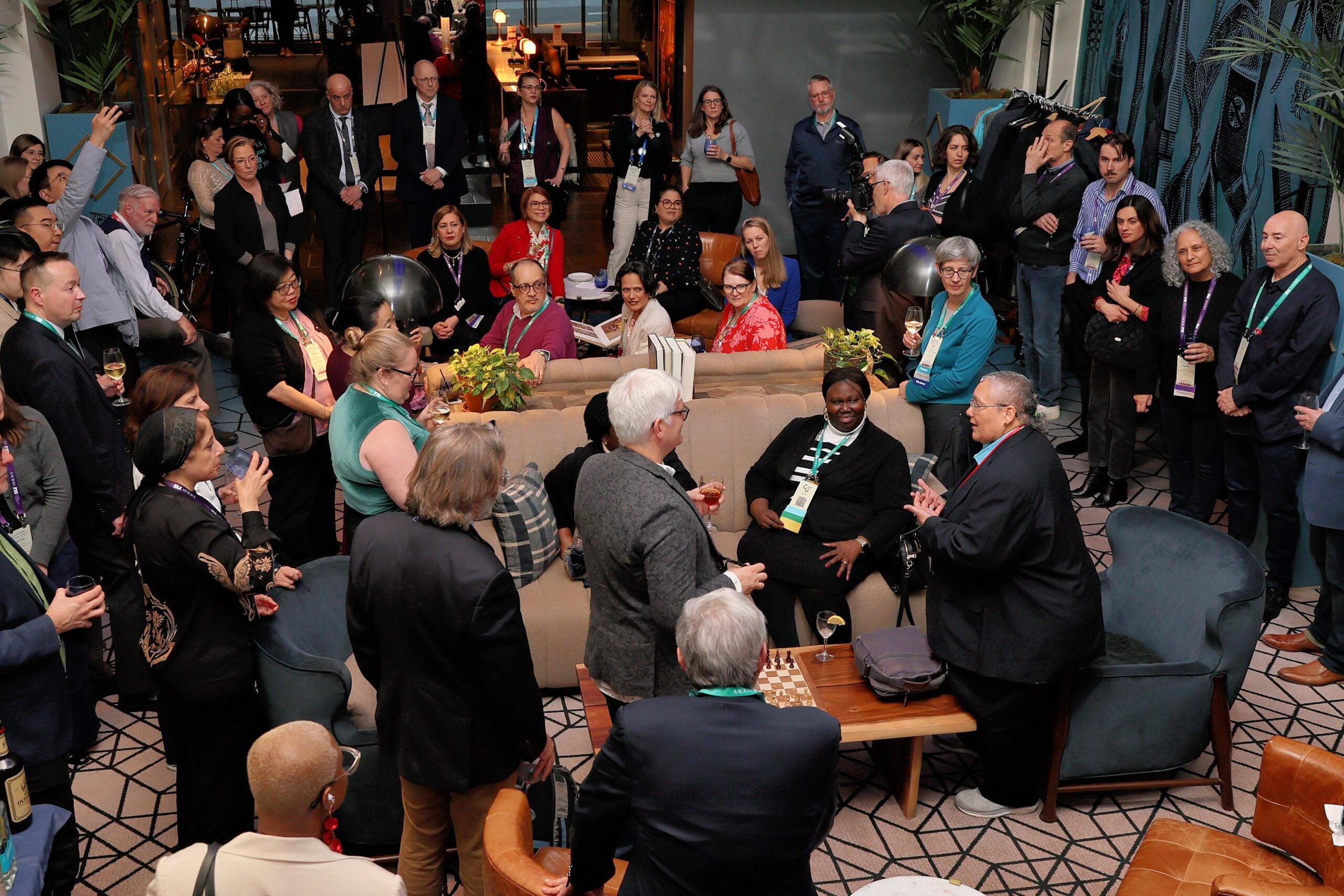 Professionals networking and discussing at an AACRAO conference session with attendees seated in a lounge setting