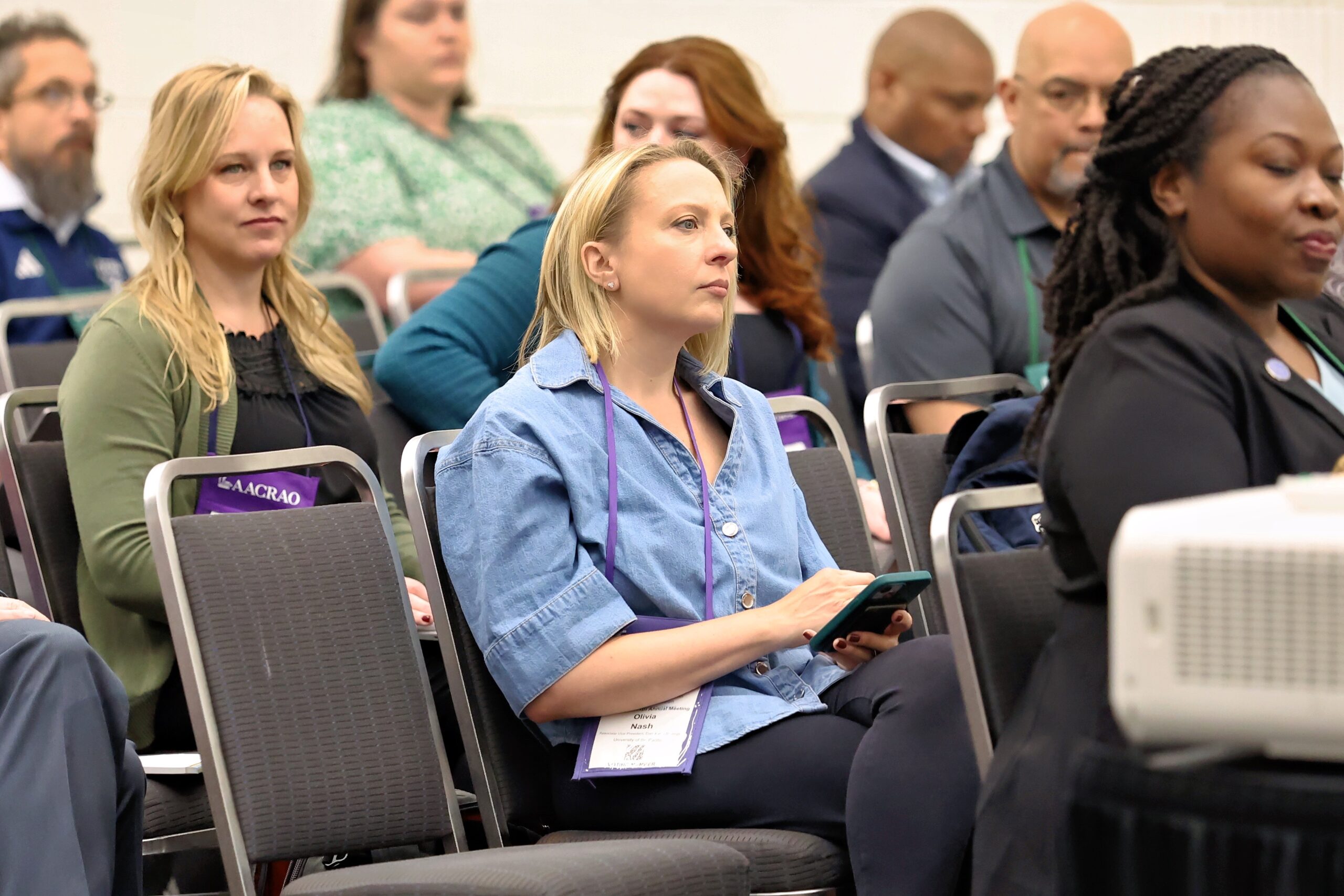 Conference attendees seated and listening attentively during a session.