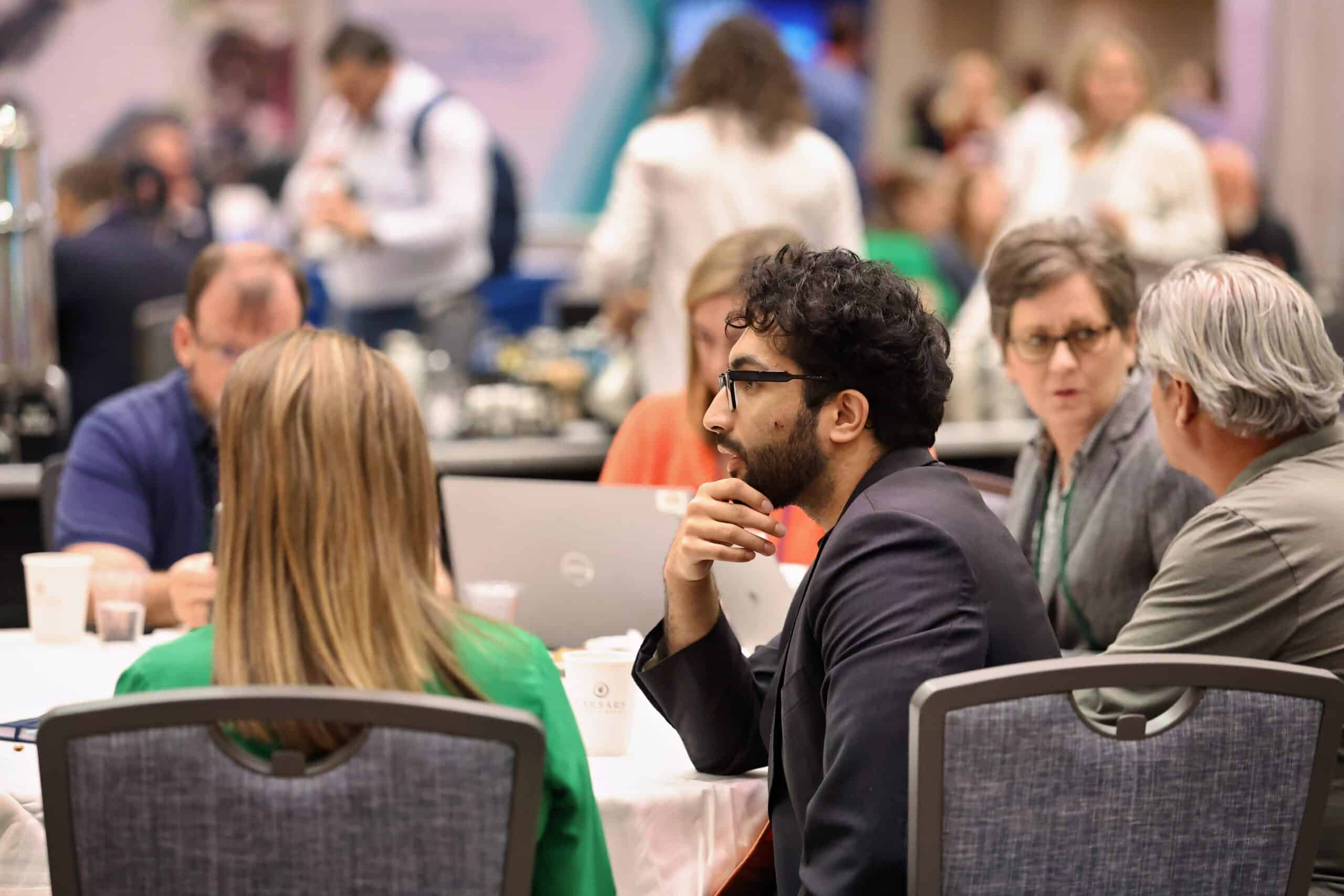 Attendees networking at tables during a conference session