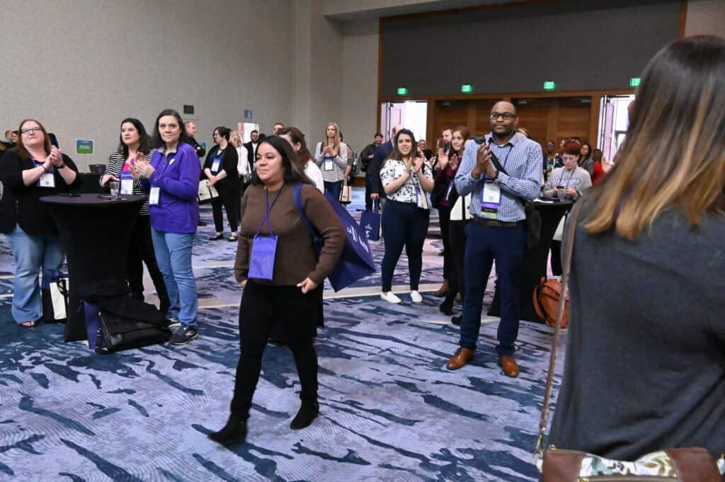 Conference attendees applauding in a ballroom