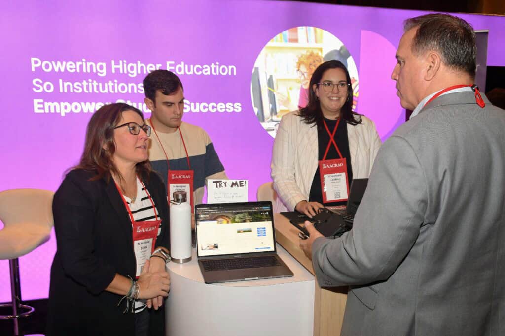 eam members demonstrate their platform at an AACRAO conference booth