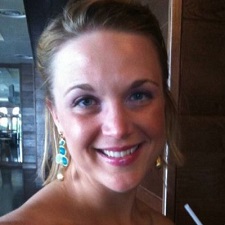 Photo a smiling female wearing earrings with what appears to be green precious stones.