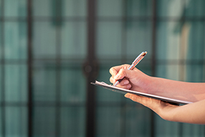 Woman holding a notepad and pen
