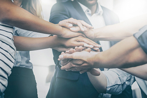 group of people stack their hands together
