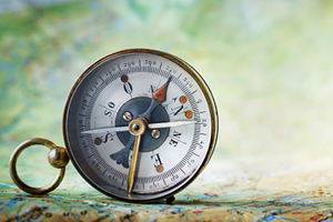 ornate compass standing on its side on top a granite surface