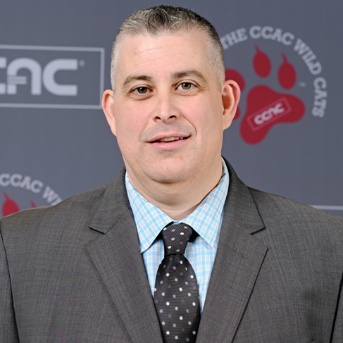 Portrait of a man in a suit at an event backdrop