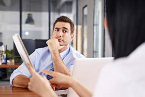 male with his hand on his chin looks skeptically at someone out of frame
