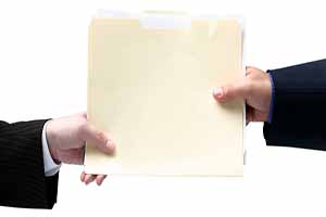 two hands exchanging a manilla folder