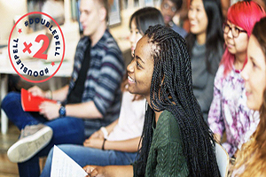 Diverse group of students smiling eagerly at someone out of frame.