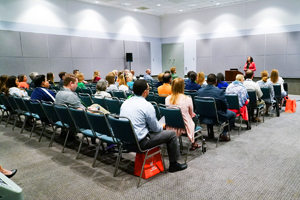 photo of audience in a room with grey walls