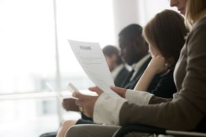 group of applicants wearing business attire silently look over a sheet