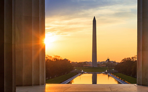 photo taken from the perspective of the Lincoln memorial looking at the reflection pool and Washington monument at sunset