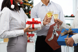 People toasting their glasses together at an office Christmas party.