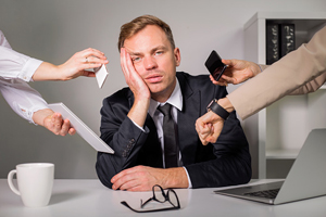 exhausted male is overwhelmed by phone calls and deadlines