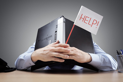 Figure covering their head with a laptop while holding up a white flag that says "help".
