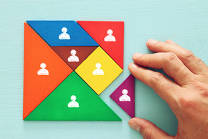 colorful puzzle made out of various shapes with a hand putting the final pieces into place