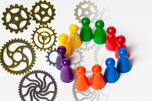 various intersecting gears cast a shadow on a group of board game figurines