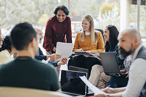 business people sitting in a circle smiling and conversing openly