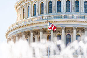 Close up of the U.S. capitol with United States Flag in front.