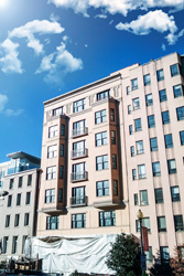 Photo of a nondescript high rise building with blue skies visible over head.