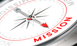 Compass with it's needle pointing to the word "mission" rather than true north.