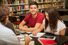 Three students studying together in a library.