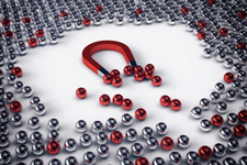 Mass of silver and red metal ball bearings with a magnet in the center that's attracting the red balls to itself.