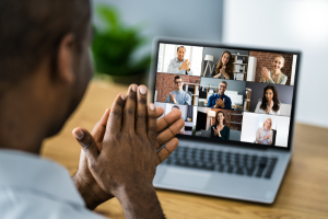 Video call on a laptop screen showing multiple people in a grid layout