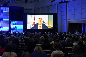 Large crowd of session attendees in ballroom.