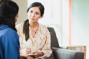 female listening empathetically to another figure whose back is to the camera