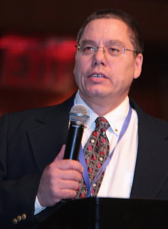 Man speaking into a microphone at a podium