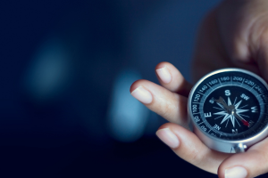 Hand holding a metal compass.