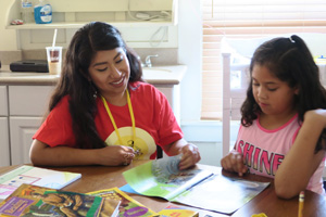 mother and daughter read together at the kitchen table