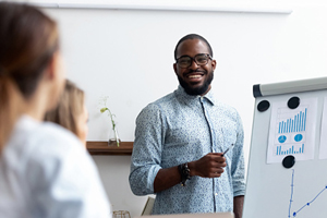 businessman standing in front of colleagues presenting chart