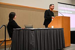 Two speakers presenting a session in front of an audience.