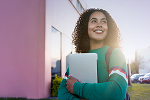 Young woman with laptop going to school.