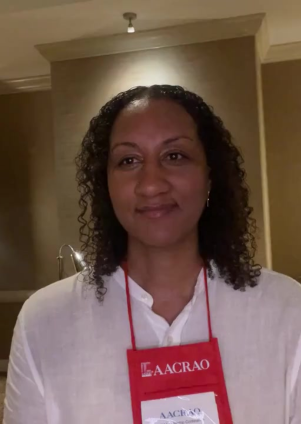 Portrait of a woman wearing a conference badge and lanyard in an indoor setting