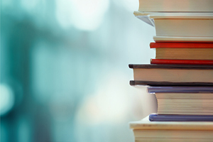 stack of books with a blurred turquoise background