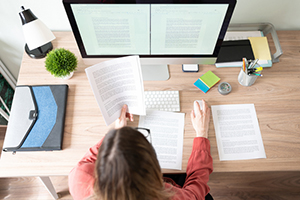 person seated at a desk while working on their computer