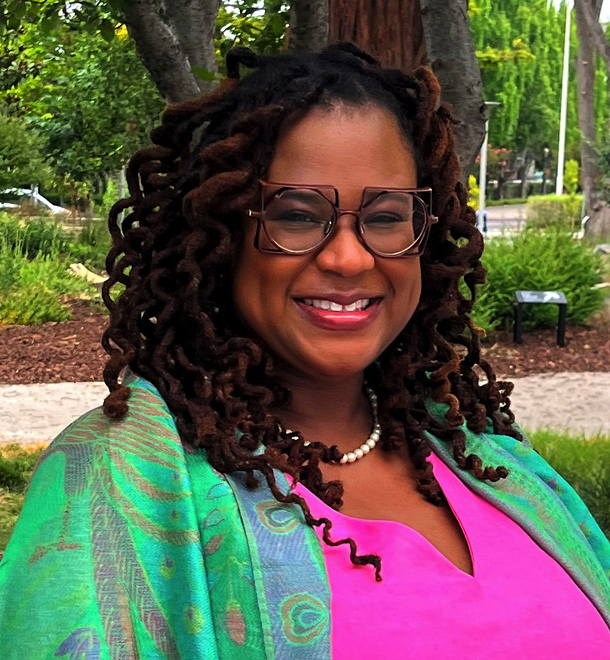Smiling woman with glasses and braided hair outdoors in a park