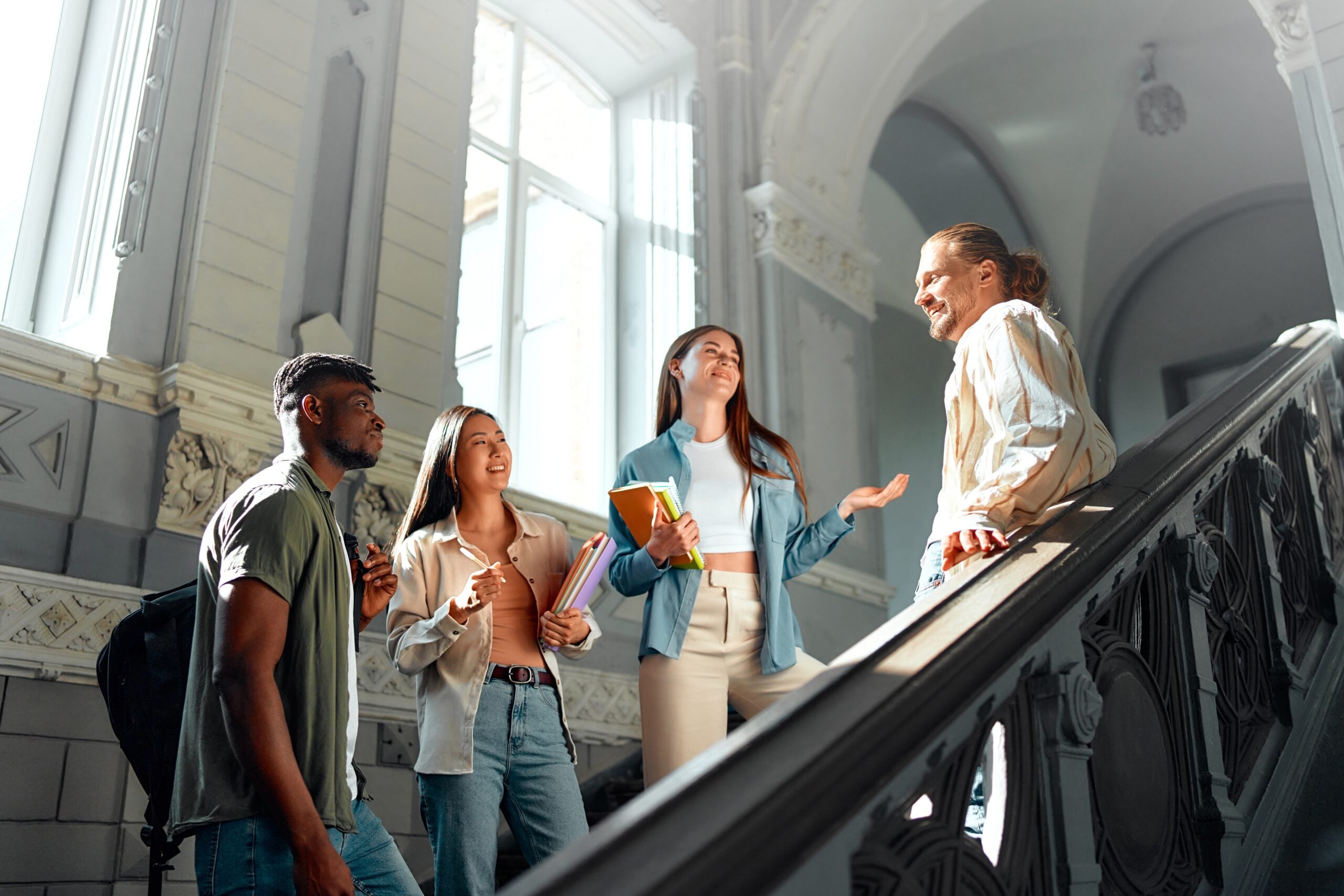 A group of students chatting on a staircase in a university building.