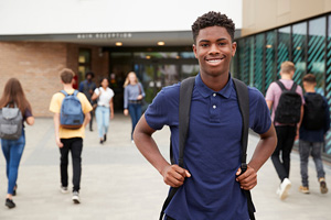 smiling student with backpack on campus