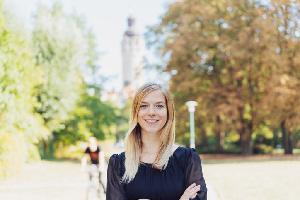 Smiling female student standing outside on a college campus.